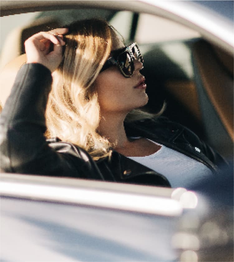 運転するサングラス姿の女性
